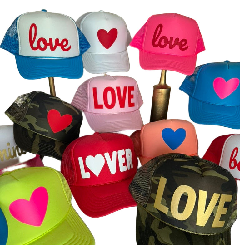 Collection of colorful caps with 'love' and heart designs on a white background