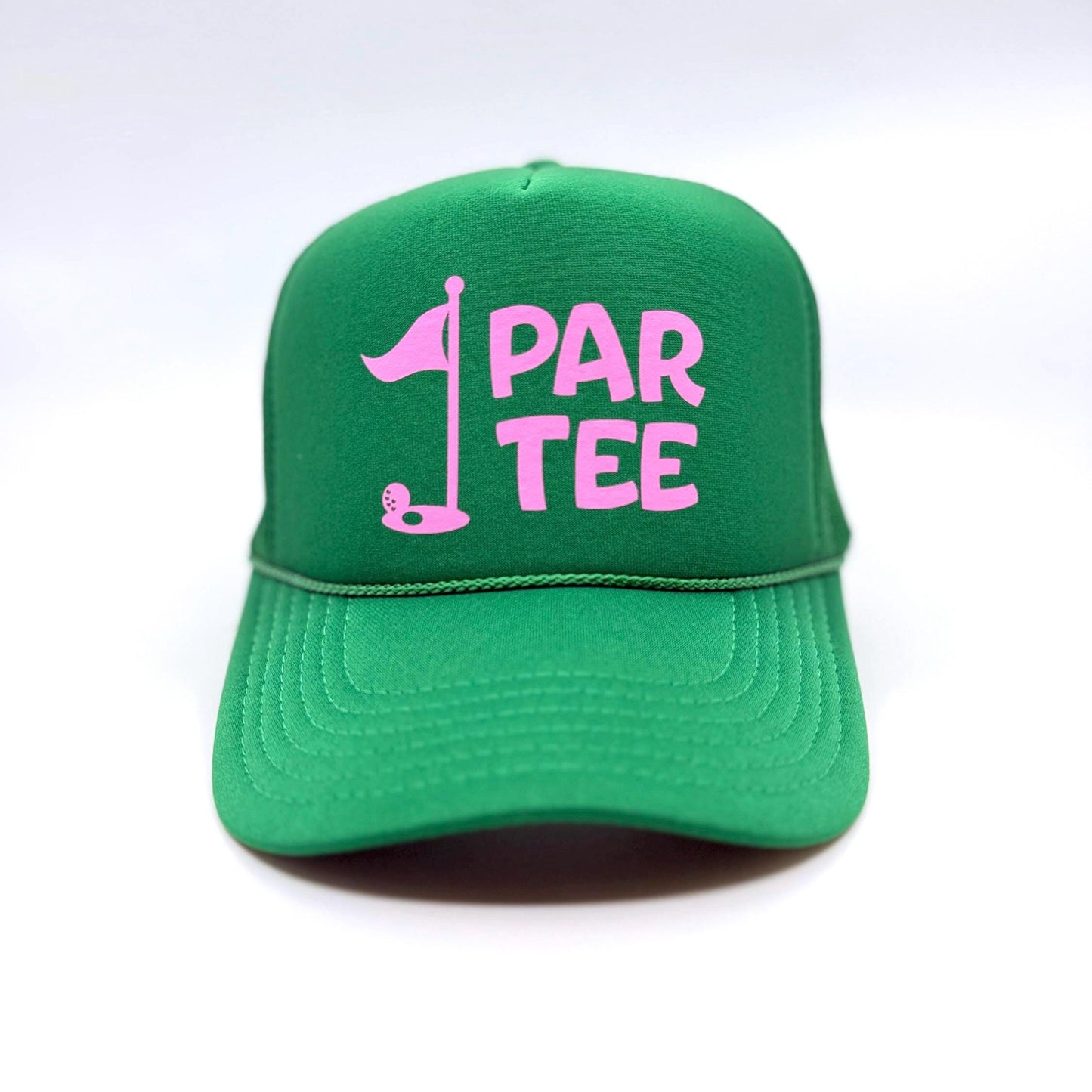 A green trucker hat with pink lettering that says 'PAR TEE.' The hat features a pink golf flag graphic. The hat is made of a breathable mesh material and has a structured, six-panel design. The adjustable snapback closure ensures a comfortable fit. This golf-themed hat is perfect for the course or everyday wear.