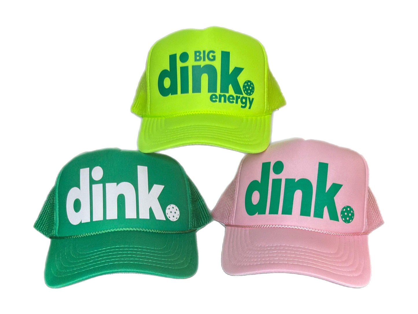 Three trucker hats with the word 'dink' in large letters. The top hat is neon green with green text and the words 'BIG DINK energy'. The middle hat is green with white text. The bottom hat is pink with green text. Each hat has a mesh back and a pickleball graphic. Makes a great gift for pickleball lover or for a group trip, tournament or any celebration!