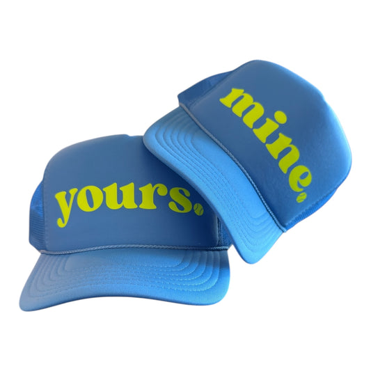 Two blue caps with 'yours.' and 'mine.' text on a white background