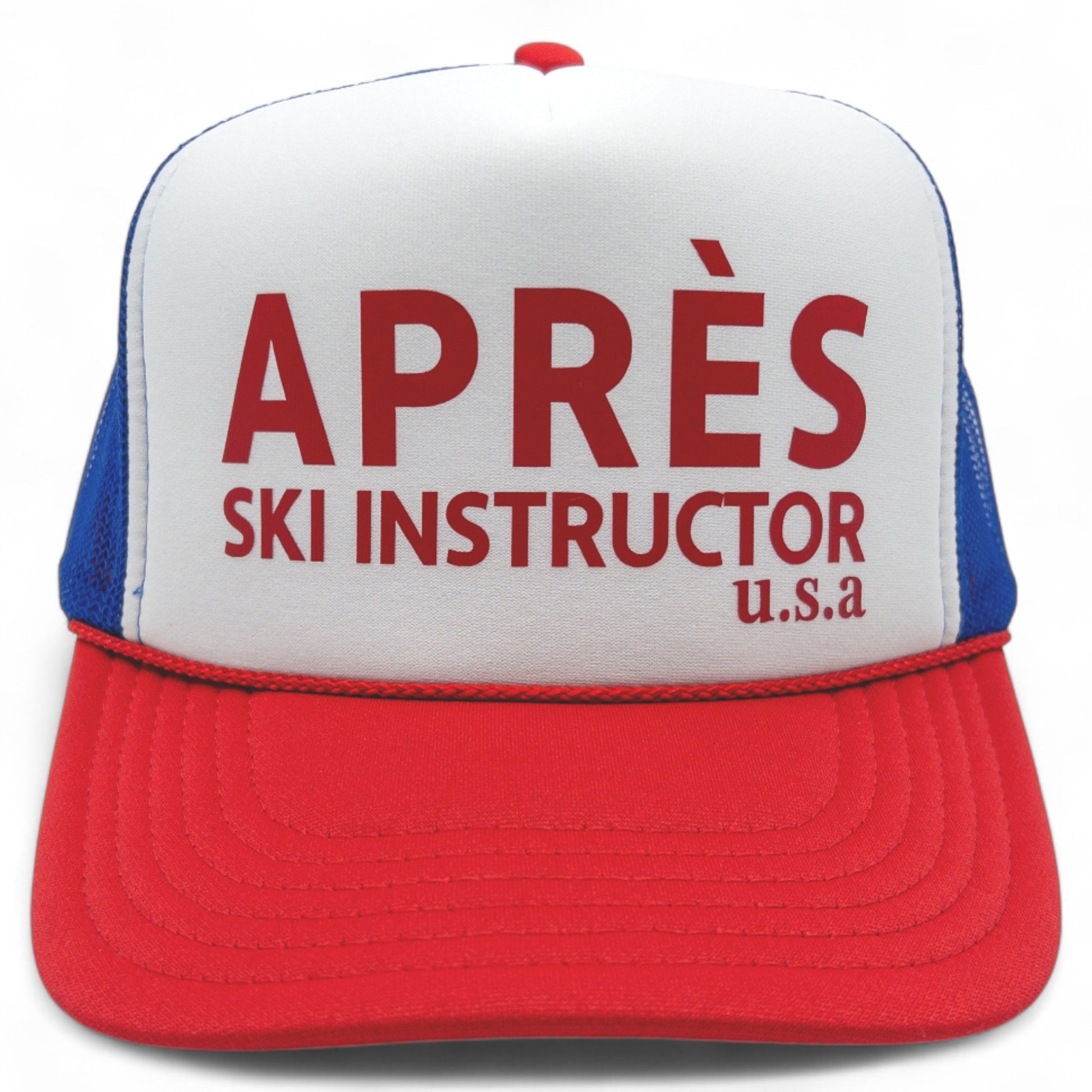 Red, white and blue foam trucker hat with mesh back and bold red “Après Ski Instructor U.S.A” text on the front.