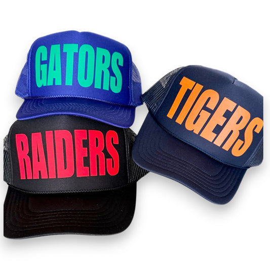 Set of three custom foam trucker hats with bold “GATORS,” “TIGERS,” and “RAIDERS” text in bright team colors. Customize your spiritwear with your favorite mascot.