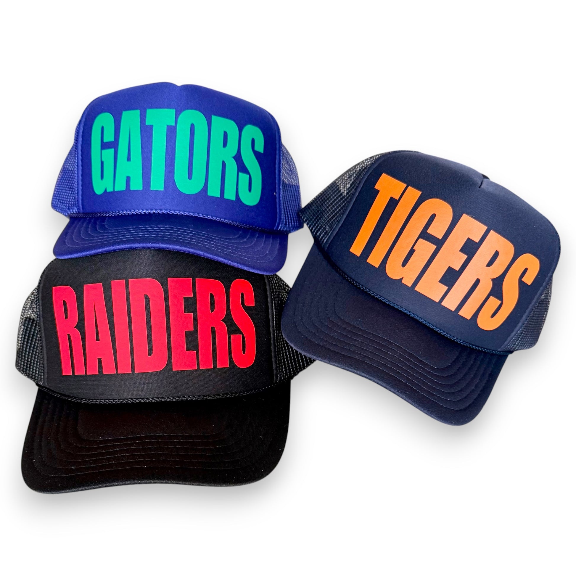 Three baseball caps with 'GATORS', 'TIGERS', and 'RAIDERS' text on a white background