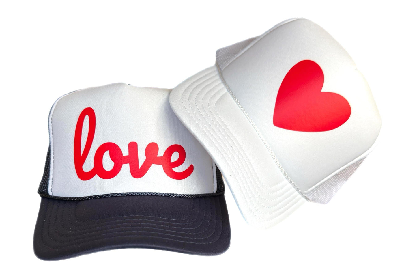 Trucker hat with word love in red script font on navy and white trucker hat, next to white trucker hat with a red heart by stevi